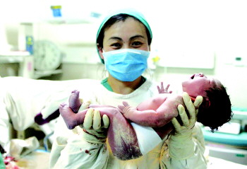 4月30日晚,济南妇幼保健院,助产士托着刚出生的婴儿.
