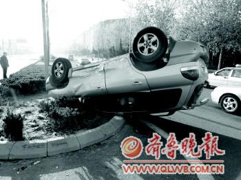 出事车辆侧翻到隔离带里,四轮朝天. 周衍鹏 摄