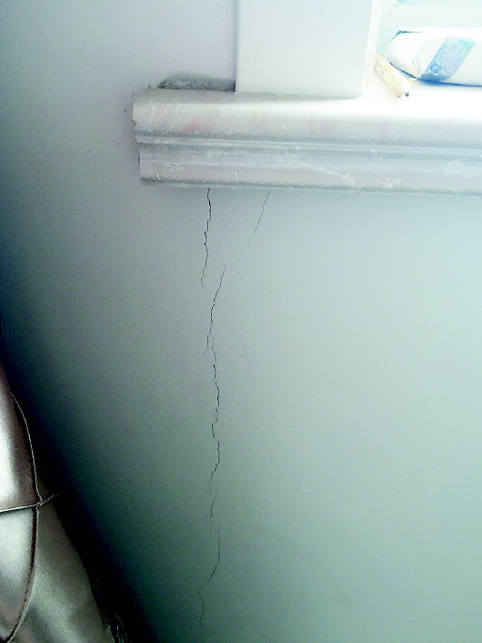 墙体裂缝从窗台延伸到地上. 记者 邢敏 摄